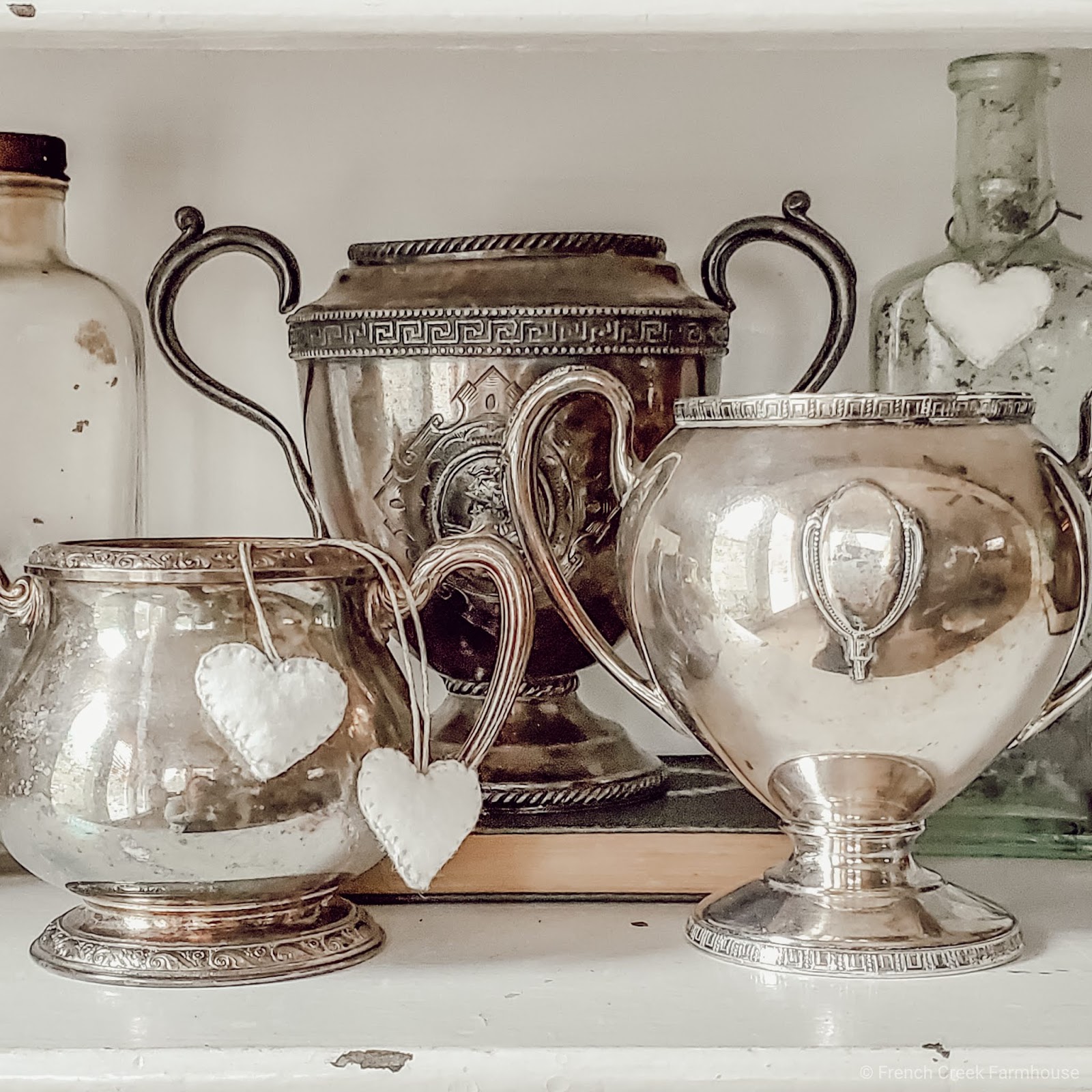 A collection of vintage trophies decorated with hand-sewn hearts for Valentine's Day