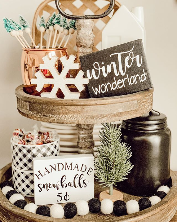 A rustic wooden tiered tray decorated for winter