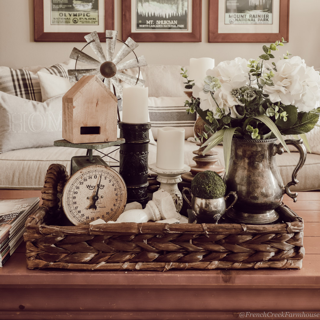 Farmhouse coffee table decor with faux white hydrangeas in a vintage silver pitcher