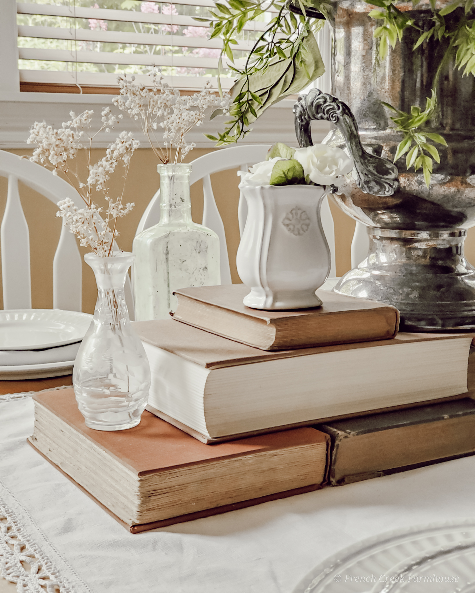 Old books used in a table centerpiece with vintage vases