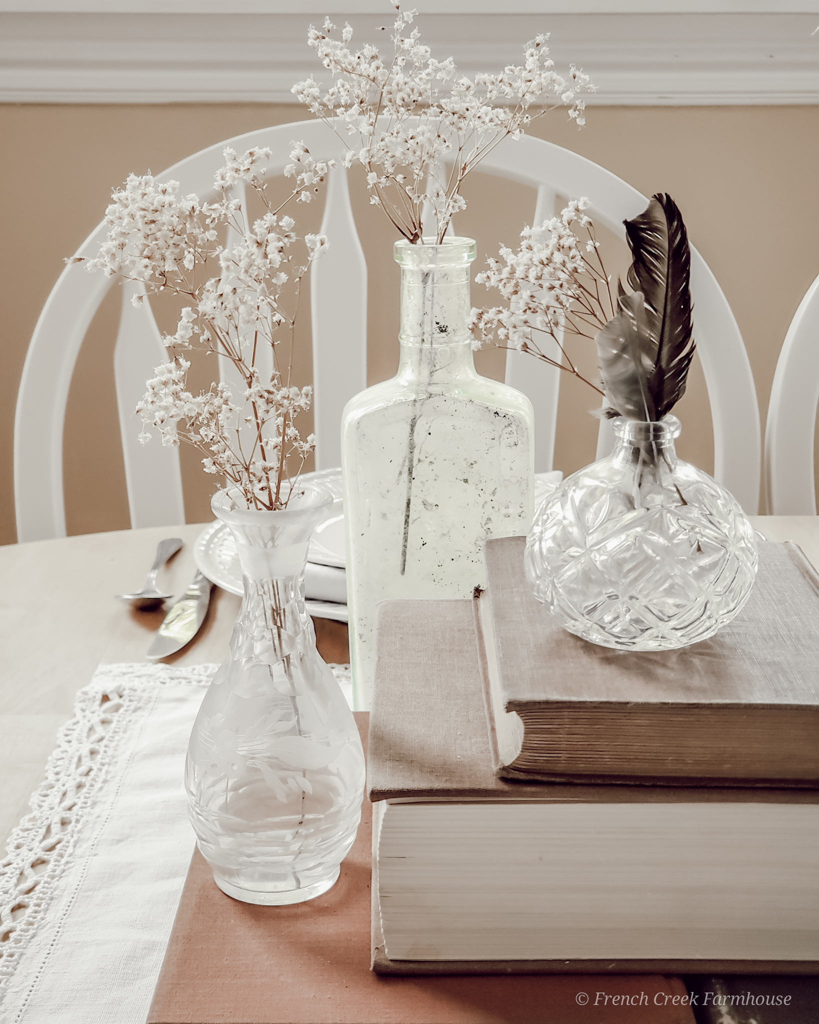 Vintage Spring Tablescape Small vintage glass bottles and vases filled with baby's breath