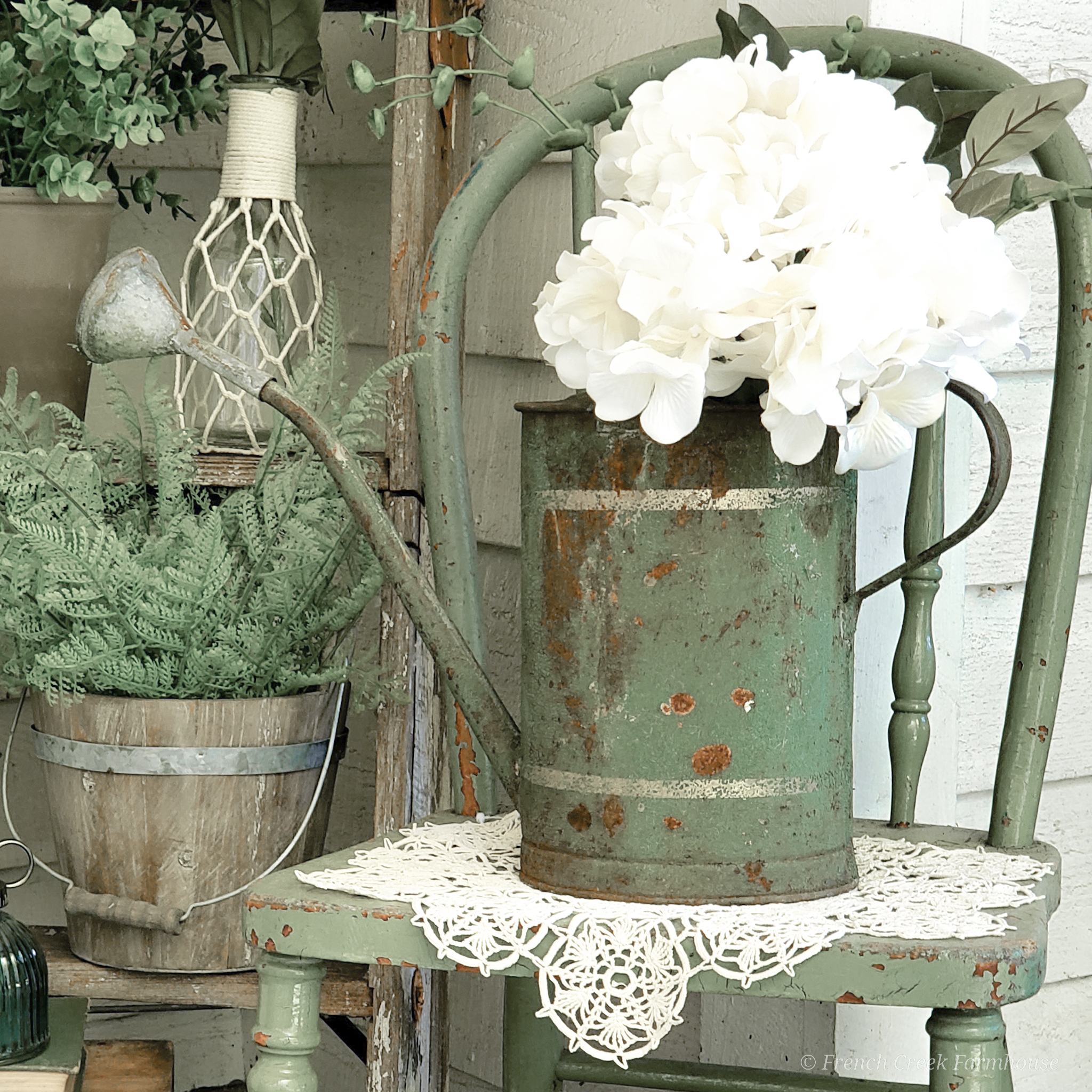 A chippy green watering can makes a pretty floral arrangement