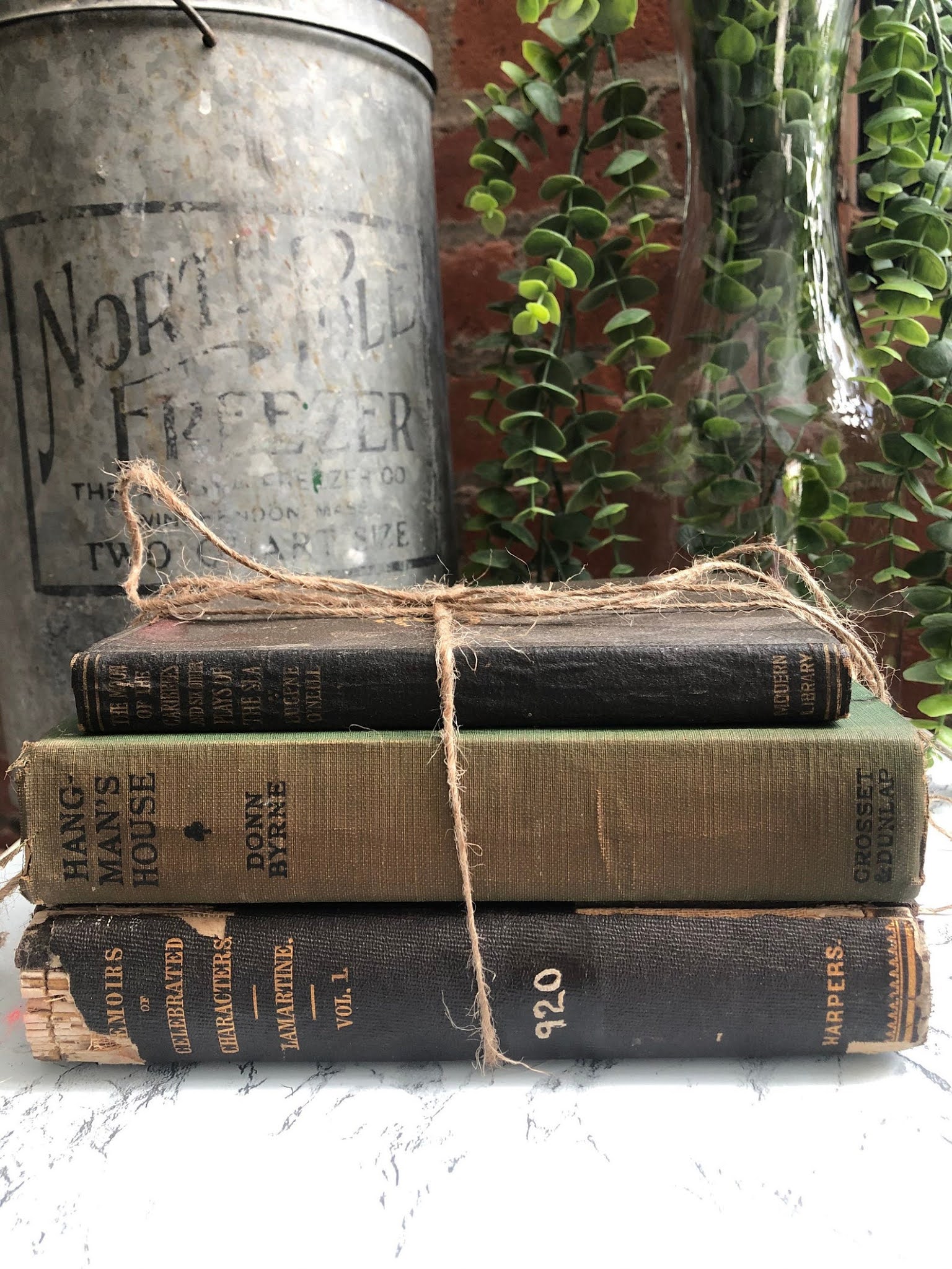 A stack of three antique books tied with string