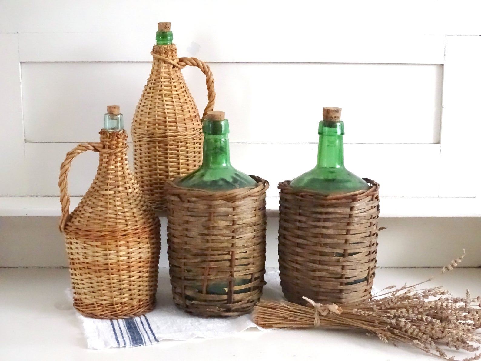 A collection of wicker wrapped demijohns