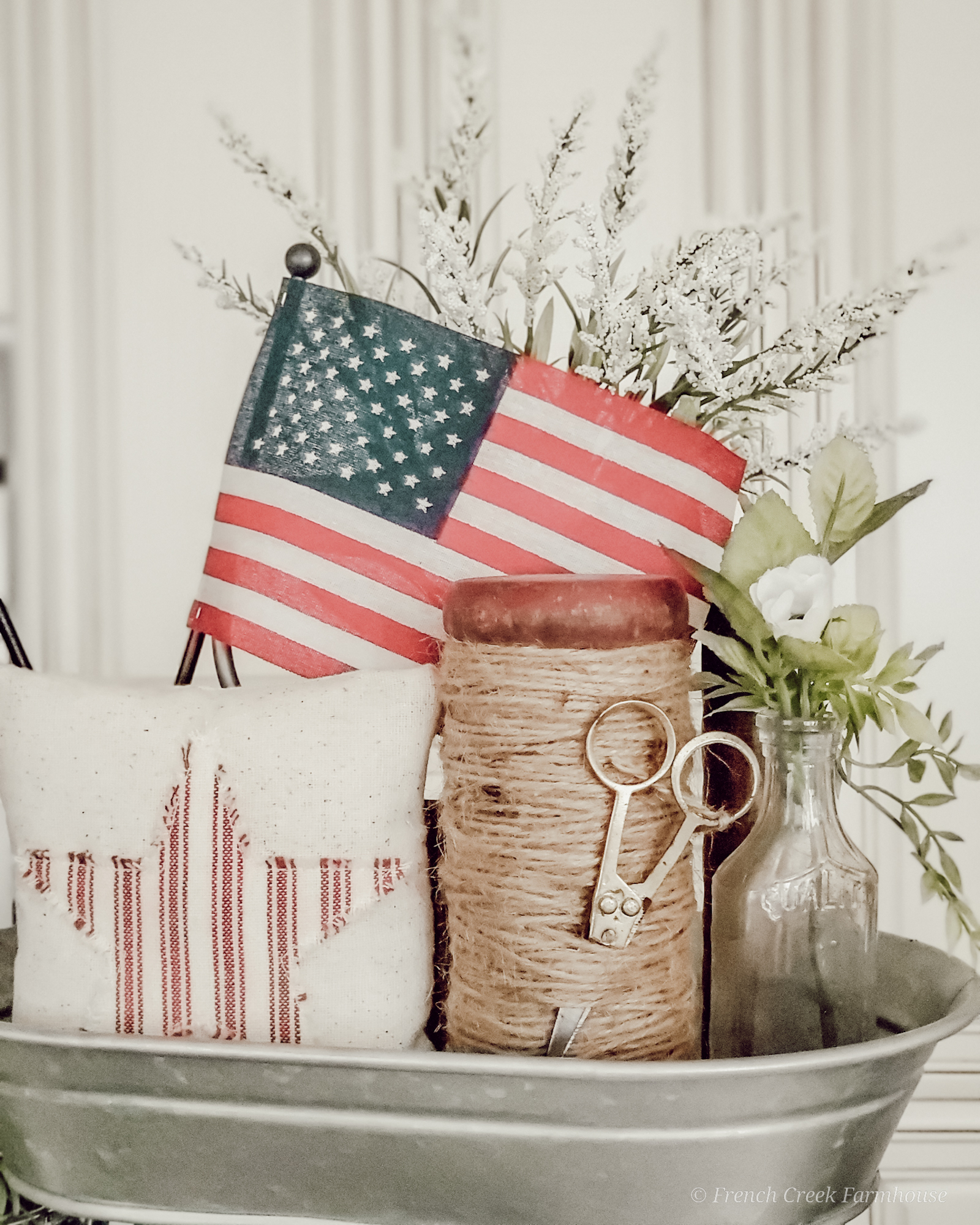 A vintage wooden spool and American flag decor