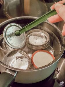 Add lids to canning jars