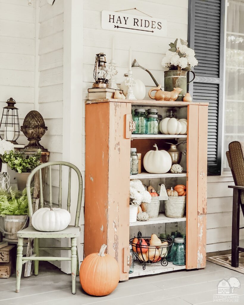 Farmhouse front porch decorated for fall with vintage touches