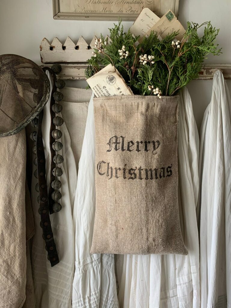 A burlap Christmas sack hung on a farmhouse wall