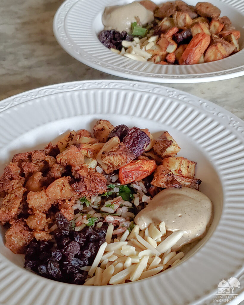 Delicious harvest grain bowl with sausage, root vegetables, and shiitake miso cashew sauce