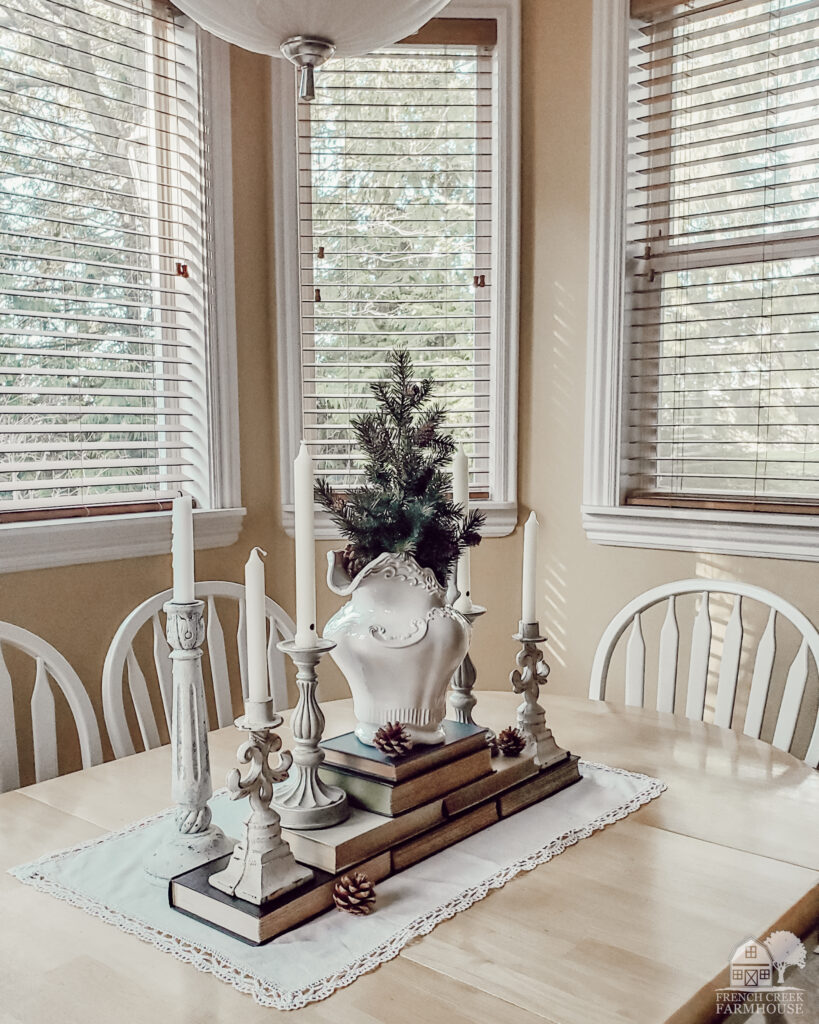 A rustic farmhouse tablescape for winter with books, candles, and ironstone