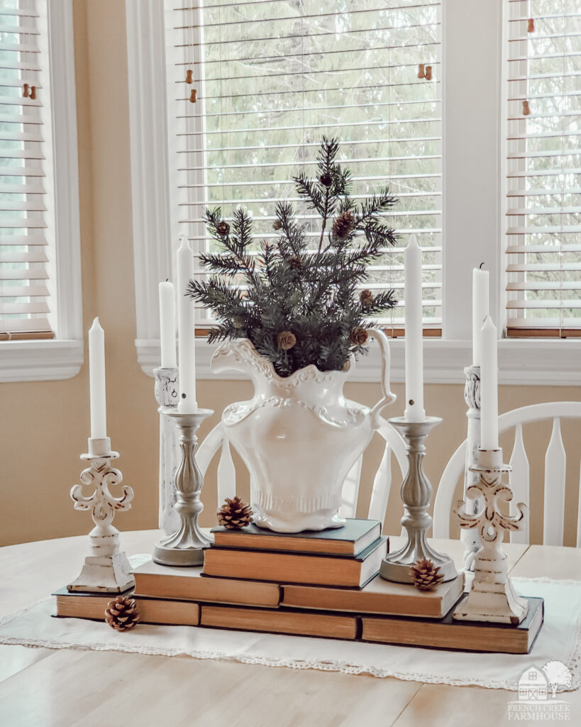 Winter farmhouse centerpiece with vintage books and ironstone pitcher