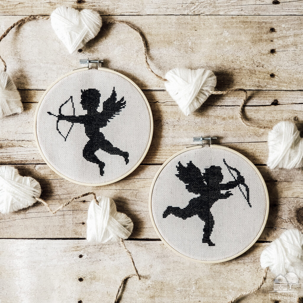 Cross-stitch cupids on a rustic barn wood background