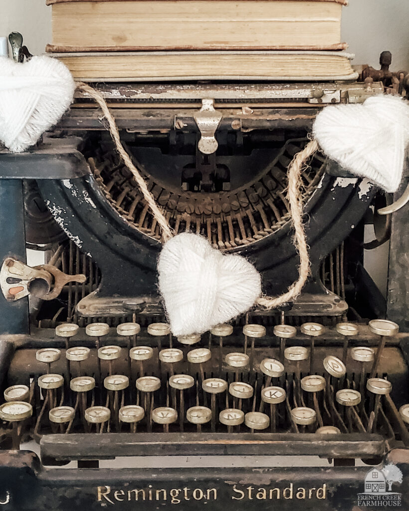 A yarn wrapped hearts garland adorns a vintage typewriter
