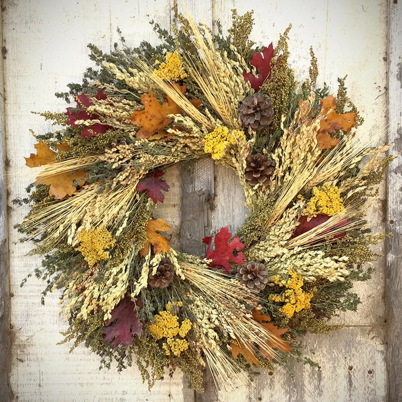 This fragrant wreath features dried yarrow, pine cones, broom corn, wheat, sweet annie, flax, and preserved fall leaves.