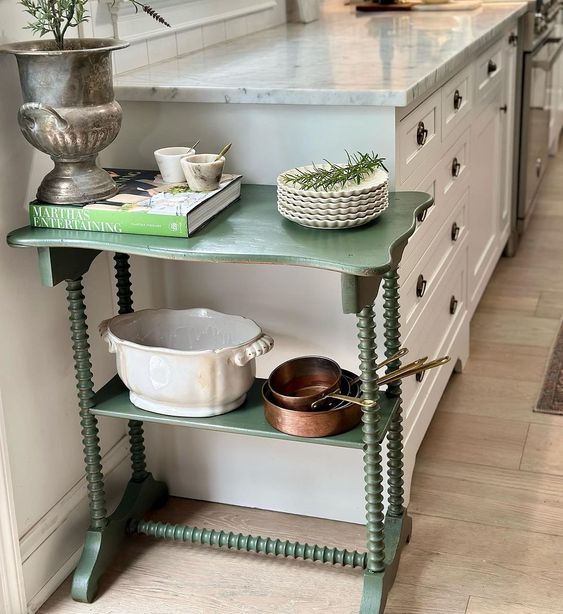 A darling painted side table makes a lovely place to store vintage serving dishes in the kitchen.